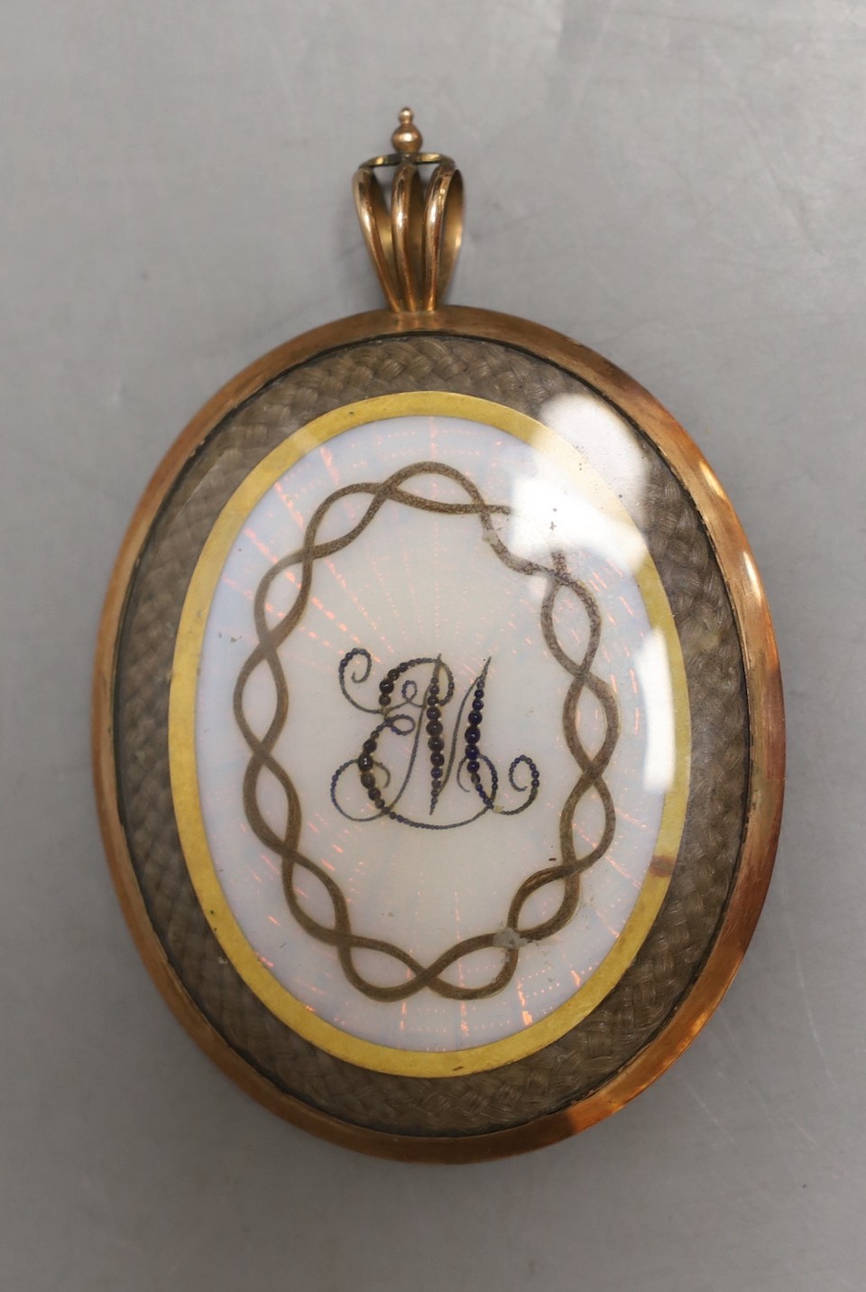 A late Georgian portrait miniature of a gentleman, with memorial hair plaque and monogram on verso.